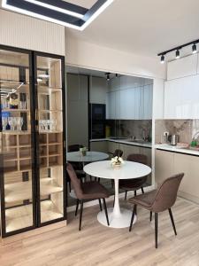 Una cocina y un comedor con mesa y sillas. en New Modern One bedroom Apartment Julija, en Skopje