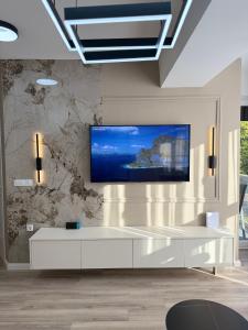 Una sala de estar con un televisor en la pared. en New Modern One bedroom Apartment Julija, en Skopje