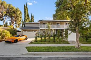 a orange car parked in front of a house at Villa Oasis: Unrivaled Views & Endless Space in Los Angeles