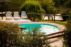 a pool with three chairs and a table and a table at Posada de Nono in Nono
