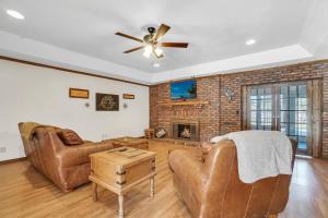 Il comprend un salon doté d'un mobilier en cuir et d'un mur en briques. dans l'établissement Oaklawn Retreat - 4 Bedroom - Sleeps 10 - Fireplace, à Vernon