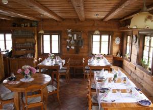 a dining room with tables and chairs with flowers on them at Zagroda Kołodzieja in Zgorzelec