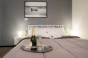 a bottle of champagne and glasses on a bed at City Lights Rome in Rome