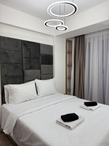 Un dormitorio con una gran cama blanca con dos toallas encima. en New Modern One bedroom Apartment Julija, en Skopje