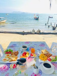 a table with food on the beach with the ocean at Koh Mook Rem Ley in Trang