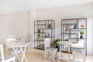 a dining room with white tables and white chairs at Chaweng Terrace in Chaweng