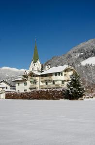 un gran edificio con un árbol de Navidad en la parte superior de una pista en Appartements St. Leonhard, en Aschau