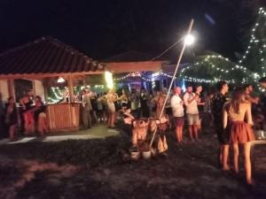 a crowd of people standing outside a house at night at Fat Monkey in Koh Rong Island