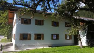 biały budynek z brązowymi oknami i drzewem w obiekcie Ferienhof Leo w mieście Steeg