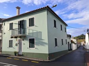 um edifício verde e branco ao lado de uma rua em Island Haven - Cantinho da Ilha em Porto Formoso