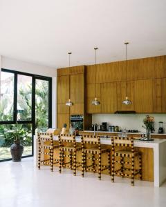 una cocina con armarios de madera, mesa y sillas en Villa Joyia Ubud, en Ubud