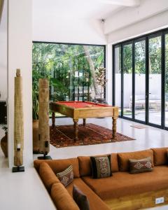 Una sala de estar con un sofá y una mesa de billar. en Villa Joyia Ubud, en Ubud