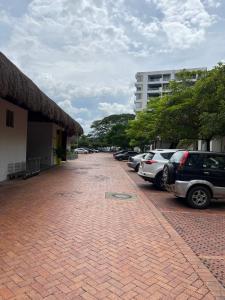 un aparcamiento de ladrillo con coches estacionados al lado de un edificio en Escapate al sol en La Morada Peñazul apartamento BBQ, en Ricaurte 42 fotos más