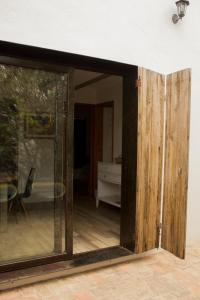 オアハカにあるCasa Guayacan Alcaláのテーブルのあるリビングルームに通じるガラスの引き戸 +2枚の写真