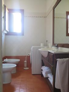 a bathroom with two sinks and a toilet and a mirror at Tenuta Lio Maggiore in Lido di Jesolo