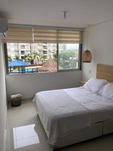 Un dormitorio con una cama grande y una ventana grande. en Escapate al sol en La Morada Peñazul apartamento BBQ, en Ricaurte