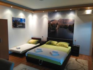 a room with two beds and a large painting on the wall at Apartments Leo in Trebinje