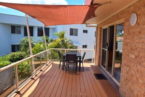 a wooden deck with a table and chairs on it at Ocean Shores 7 South West Rocks - Bring you own linen. in South West Rocks