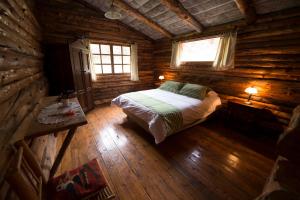 Inraki Lodge في Guaillabamba: غرفة نوم مع سرير في كابينة خشب