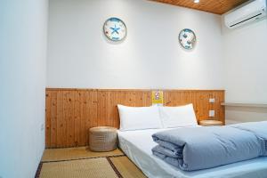 布袋海风长堤二馆民宿的卧室里有一张床，墙上挂着两个钟