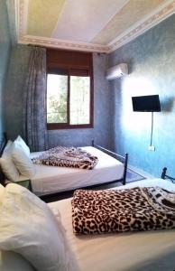 two beds in a room with a leopard print mattress at Hotel Espace Tifawine in Tafraoute