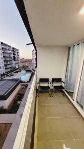 a balcony with two chairs and a view of a building at Acogedor Departamento la Serena 3D 2B wifi estacionamiento céntrico in La Serena