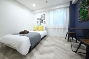 a white bedroom with a bed and a table at Shibuya WAVE 301 in Tokyo