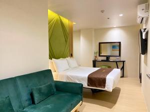 a hotel room with a bed and a couch at El Coco Boutique Hotel in Ibabang Talim