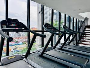 乔治市Urban Suites Georgetown Penang - Sea View & Georgetown View - High Floor - Exclusive & Cozy Stay的窗户前有三个跑步机的健身房