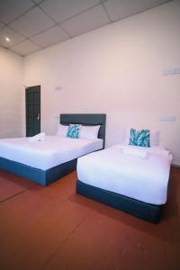 2 letti posti uno accanto all'altro in una stanza di Swing & Pillows - 75 Chulia St, Georgetown Penang a George Town