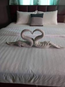 two snakes forming a heart on a bed at Mgrand Hotel in Ban Non Sombun