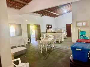 a dining room with white tables and chairs at Toca do coelho in Aquiraz