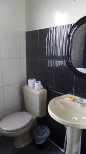 a bathroom with a toilet and a sink at Blue Pine Farm Lodge Cabanas in Coroico