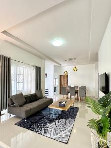 a living room with a couch and a table at Cozy 3 BR house & green lawn near Airport & Old town in Chiang Mai