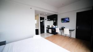 TV a/nebo společenská místnost v ubytování Homey Studio No Kitchen at Grand Darmo Suite Apartment By Travelio
