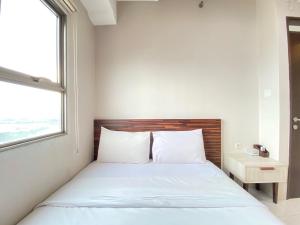 a bedroom with a bed and a window at Chic and Cozy 2BR at Mekarwangi Square Cibaduyut Apartment By Travelio in Bandung +10 photos