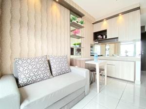 a living room with a couch and a table at Chic and Cozy 2BR at Mekarwangi Square Cibaduyut Apartment By Travelio in Bandung