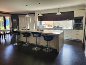 a kitchen with a large island with bar stools at Lucky House in Point Cook