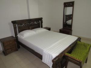 1 dormitorio con cama, silla y espejo en Apartamento en El Rodadero - El Morro, en Santa Marta