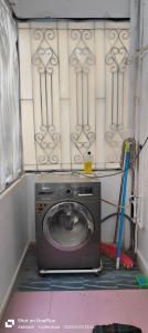 eine Waschmaschine in einer Ecke eines Zimmers in der Unterkunft The Cozy Nest 1 in Hyderabad + 7 Fotos