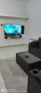 ein Wohnzimmer mit einem Flachbildfernseher an der Wand in der Unterkunft The Cozy Nest 1 in Hyderabad