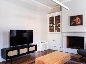 a living room with a fireplace and a flat screen tv at The Macquarie in Hobart