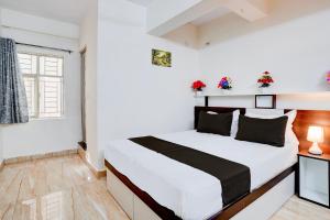 a white bedroom with a bed and a window at Super Hotel O SGR Palace in Bengaluru