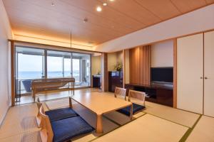 白浜町にあるホテル三楽荘のテーブルとテレビのあるリビングルーム