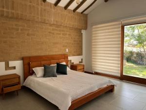 um quarto com uma cama e uma parede de tijolos em refugio natal1 em Villa de Leyva