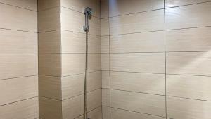 a bathroom with a shower with a shower head at Comfort Studio Room at Margonda Residence 5 Apartment By Travelio in Depok +8 photos