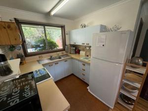 a kitchen with a white refrigerator and a window at Church St in Bright