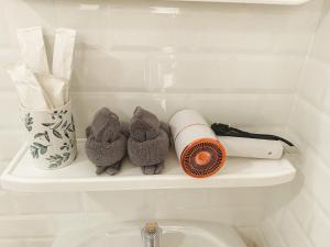 a shelf above a toilet with toilet paper and stuffed animals at Amaze at The Myth บ้านมิตร in Mae Rim