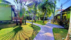 a walkway with palm trees in front of a building at Casa Fina Fine Homes in Pantai Cenang