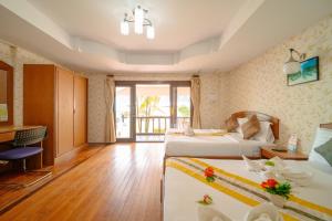 a hotel room with two beds and a desk at Chongkhao Resort- Phi Phi Island in Phi Phi Islands